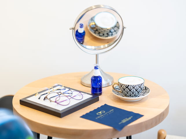 Lens, glasses and tea cup on table